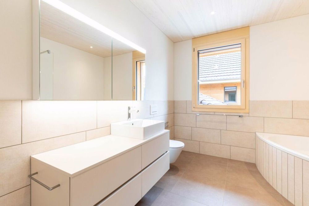Nachhaltiges Wohnerlebnis aus Holz - Grosses Badzimmer mit Dusche und Wanne