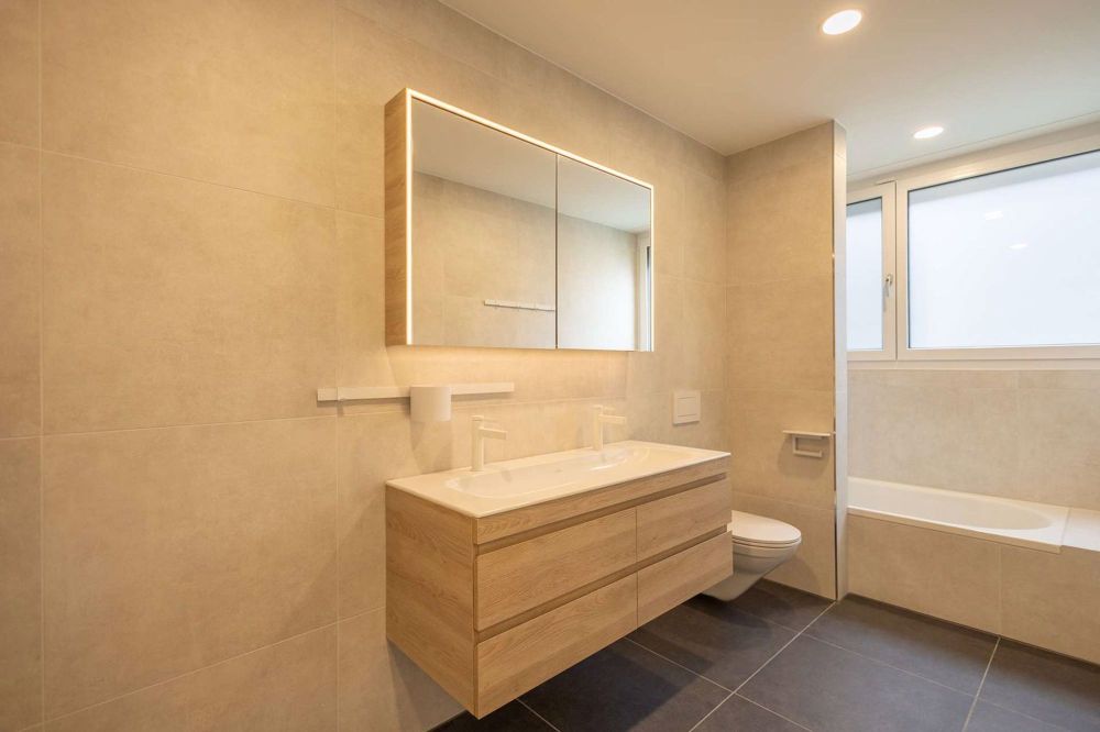 RESERVIERT: Traumhafte 6.5 Zimmer-Gartenwohnung vereint moderne Eleganz und erstklassiger Komfort in Volketswil - Familienbadezimmer mit Wanne und Platz für einen Waschturm