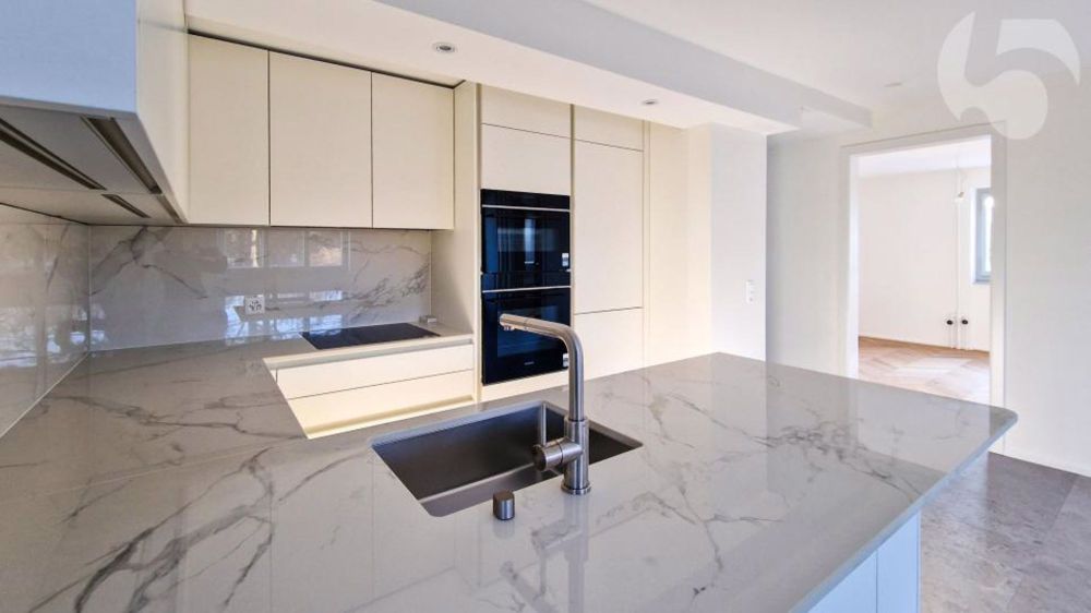 Prächtige 3,5-Zimmer-Wohnung im Erdgeschoss einer Architekten-Villa mit privatem Garten (Rasenmäher-Roboter, automatische Bewässerung) und Bahnhof LEB vor Ort. - Luxueux agencement de cuisine avec four vapeur et cave à vins, plan de travail assorti à l'entre-meuble