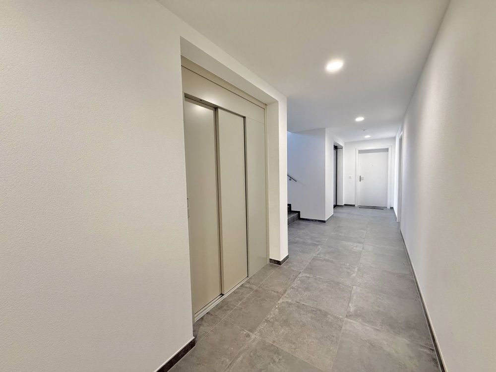 Superbe appartement neuf de 2.5 pièces avec terrasse et jardin privé - Couloir avec ascenseur