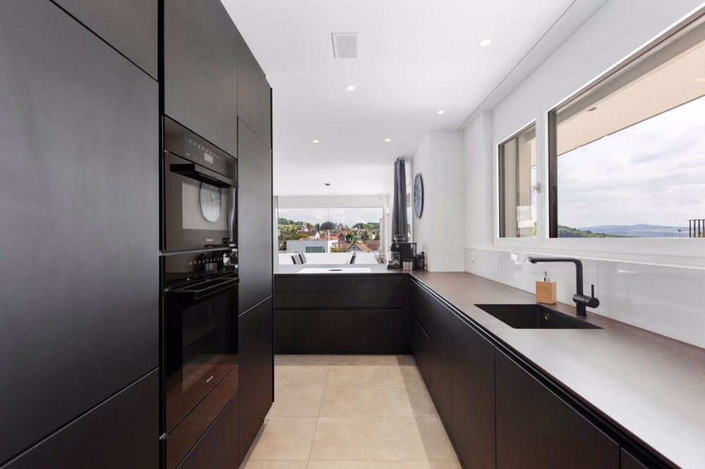 Exklusive Wohnperle mit atemberaubender Panoramasicht, vielseitigem Ra - hochwertige und exklusive Küche in mattschwarz mit einer Dekton Keramikplatte