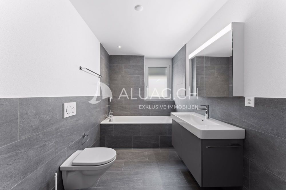 ATTRAKTIVE 4.5 ZIMMER IM JURAPARADIES - Zweites Badezimmer mit Badewanne und zeitloser Gestaltung in stilvollen Grau- und Weisstönen