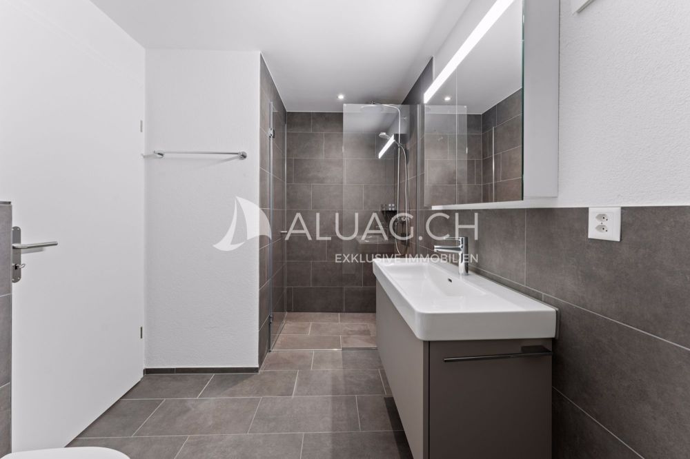 JURA LIVING - CHARMANTE 3.5 ZIMMERWOHUNG - Badezimmer mit Regendusche und zeitloser Gestaltung in stilvollen Grau- und Weisstönen