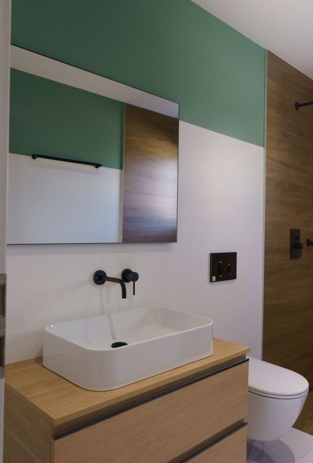 Exklusive und helle Apartments mit Ausrichtung - une salle de bains aux murs verts avec un lavabo et des toilettes blancs / a bathroom with green walls and a white sink and toilet