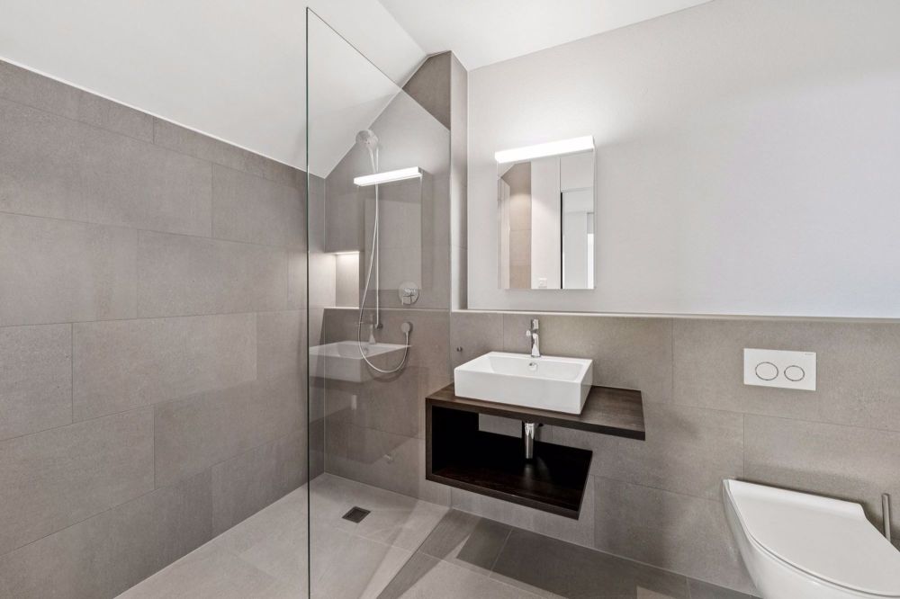Licht. Raum. Neubeginn - Erstbezug in Beromünster - Design trifft Funktion: Badezimmer mit bodengleicher Dusche und exklusiven Feinsteinzeugplatten