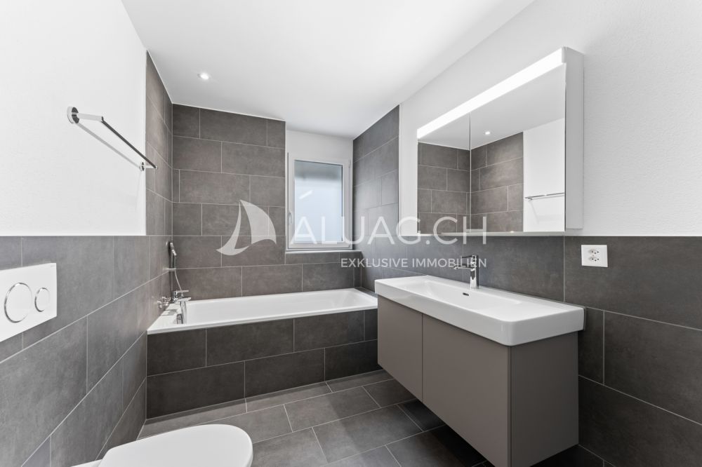 NEUBAU HIGHLIGHT - 4.5 ZIMMER MIT BALKON - Weiteres Badezimmer mit Badewanne und zeitloser Gestaltung in stilvollen Grau- und Weisstönen