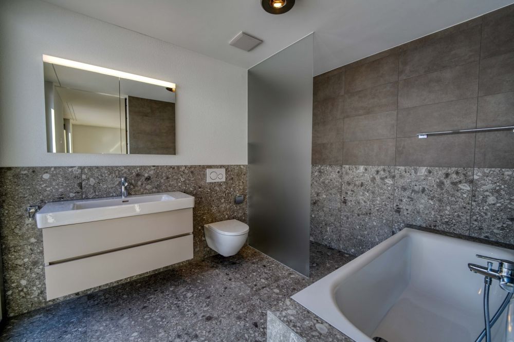Erstklassige 4.5-Zimmerwohnung mit hochwertigem Ausbau - Badezimmer en-suite mit mineralischer Materialität