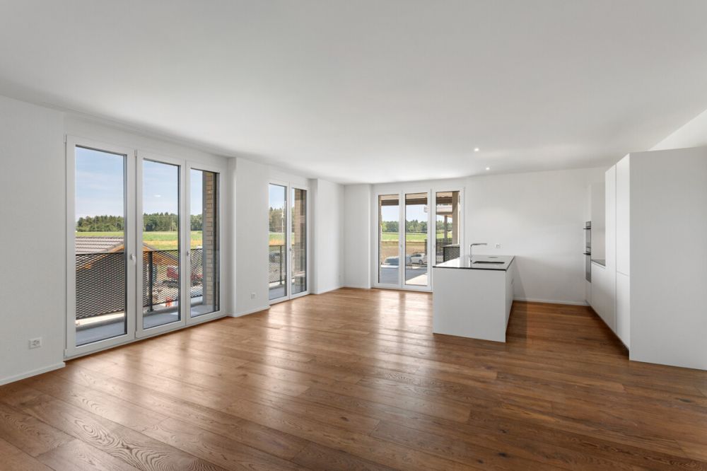 Erstbezug im Ziegelei-Quartier: Hochwertige 4.5-Zimmer-Neubauwohnung - Lichtdurchflutet: Fliessender Übergang von der Kochinsel in den Wohnbereich.