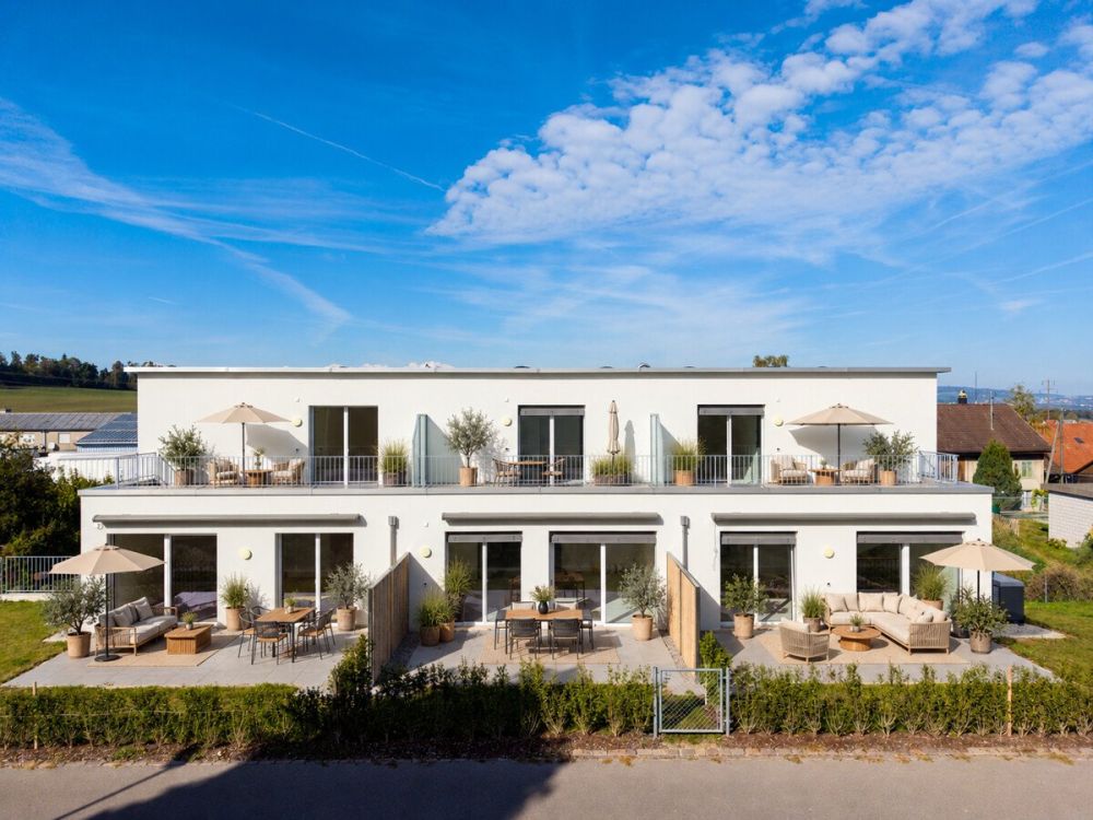 Modernes Reihenmittelhaus mit hohem Wohnkomfort - Moderne Terrassenmöblierung am weißen Wohnhaus
