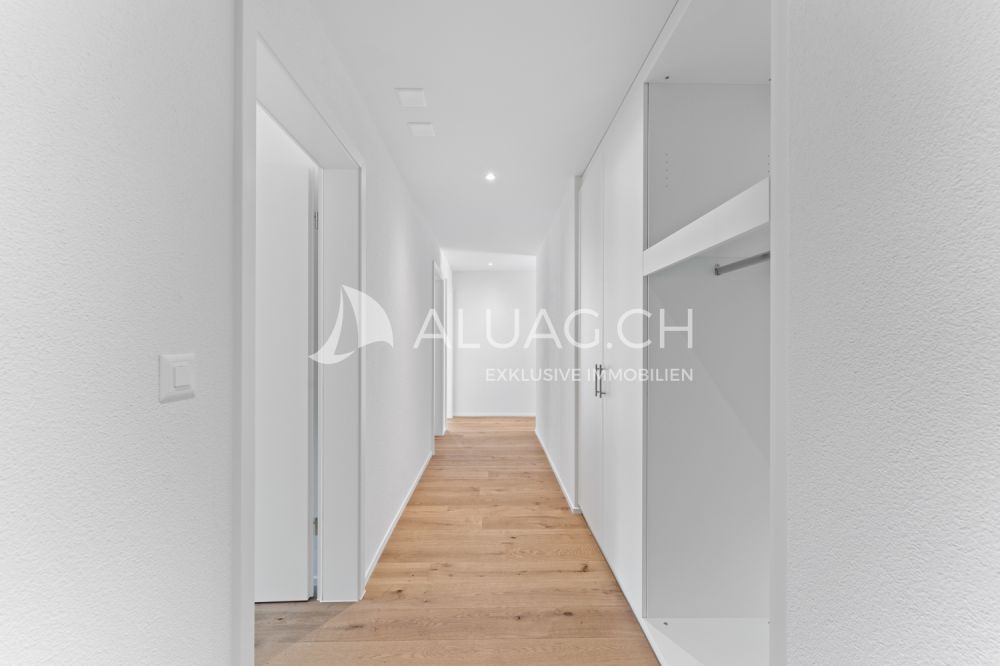 NEUBAUTRAUM 4.5 ZIMMER IM HERZEN DER NATUR - Einladender Eingang mit hochwertigen Einbauschränken und stilvoller Ausführung