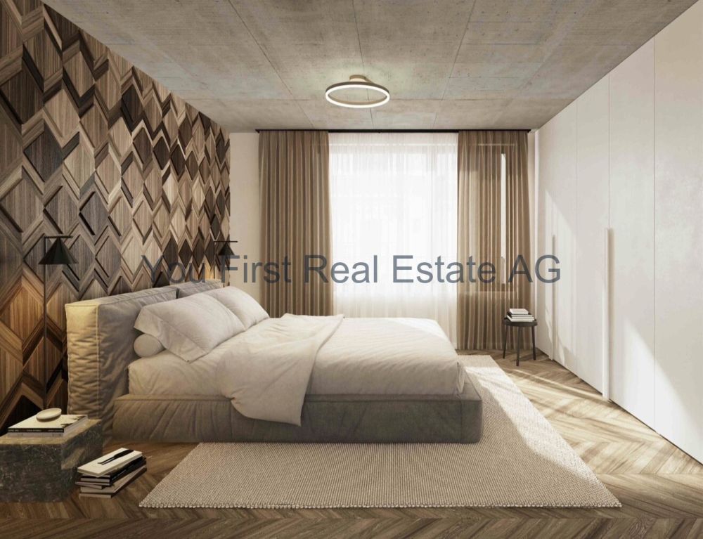 Wohnung W04  2.5-Zimmer Geschosswohnung mit Loggia - Hauptschlafzimmer mit Deckenleuchte und großflächiger Fensterfront