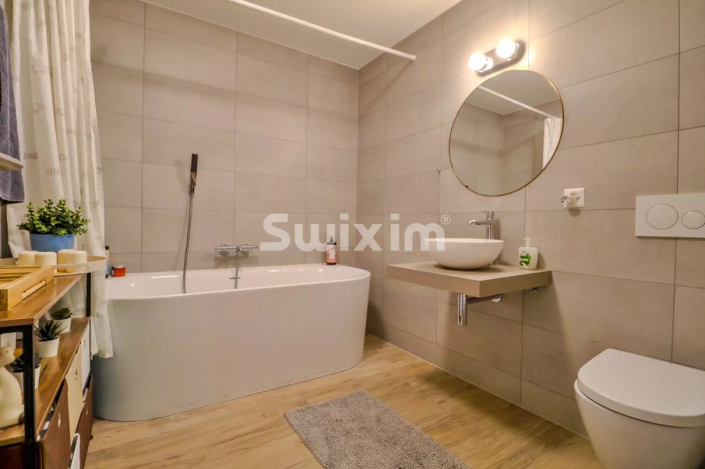 Exclusivité ! Vivez dans un village & confort :Appartement avec grande terrasse - Salle de bain moderne avec baignoire et lavabo suspendu.