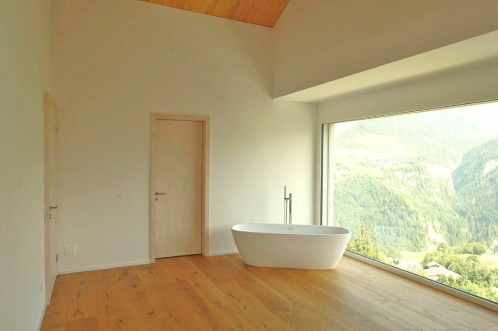 Einfamilienhaus mit Einliegerwohnung als Erstwohnsitz in Cumbel - Das grosse Doppelschlafzimmer mit Wanne und herrlicher Aussicht.