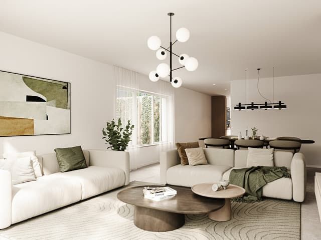 Magnifique maison individuelle à Courfaivre JU - Spacious living room with large windows, white sofas, round wooden coffee table, abstract artwork, and a modern chandelier lighting fixture.