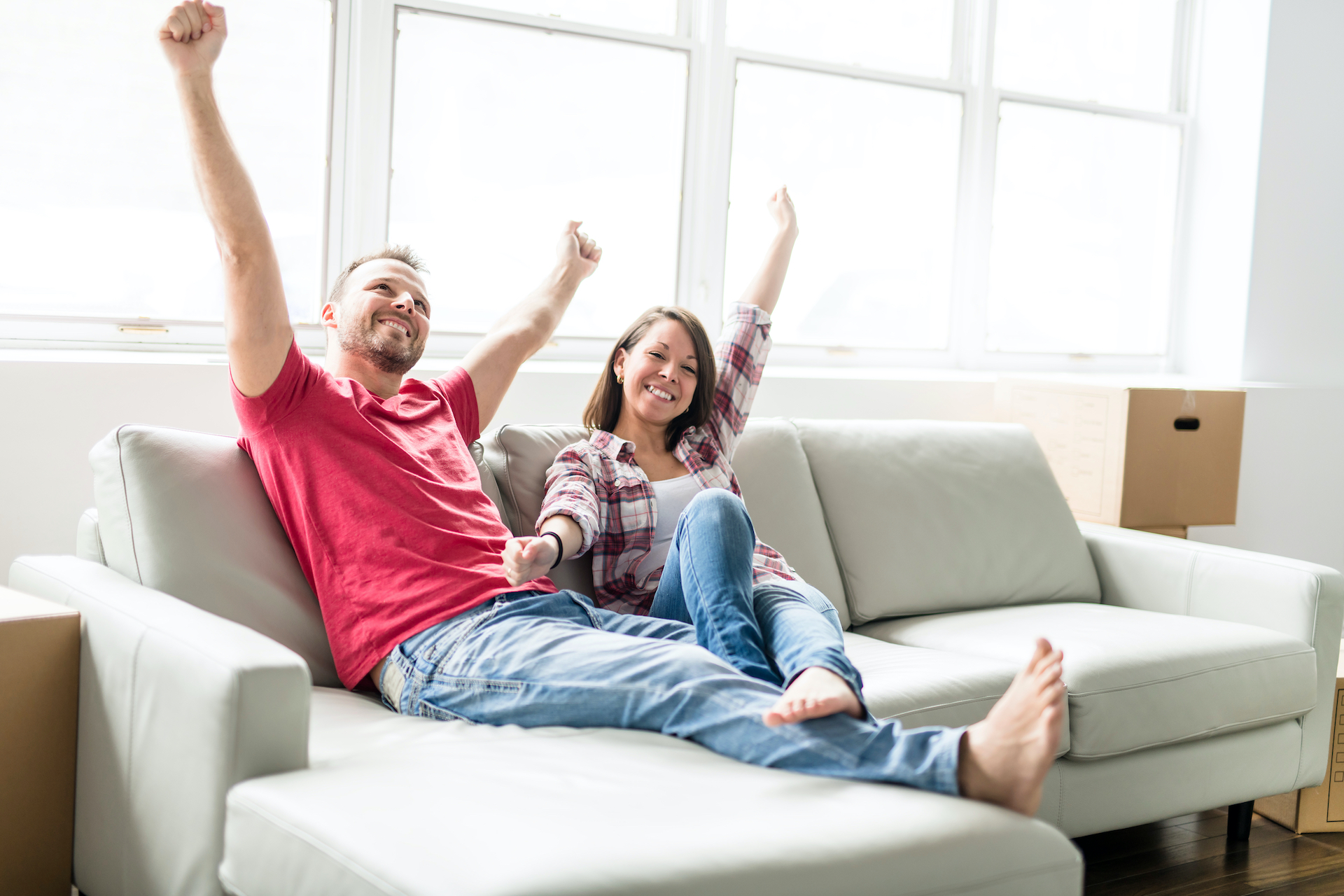 Couple,Sitting,Together,On,Sofa,At,Home,Happy,To,Move