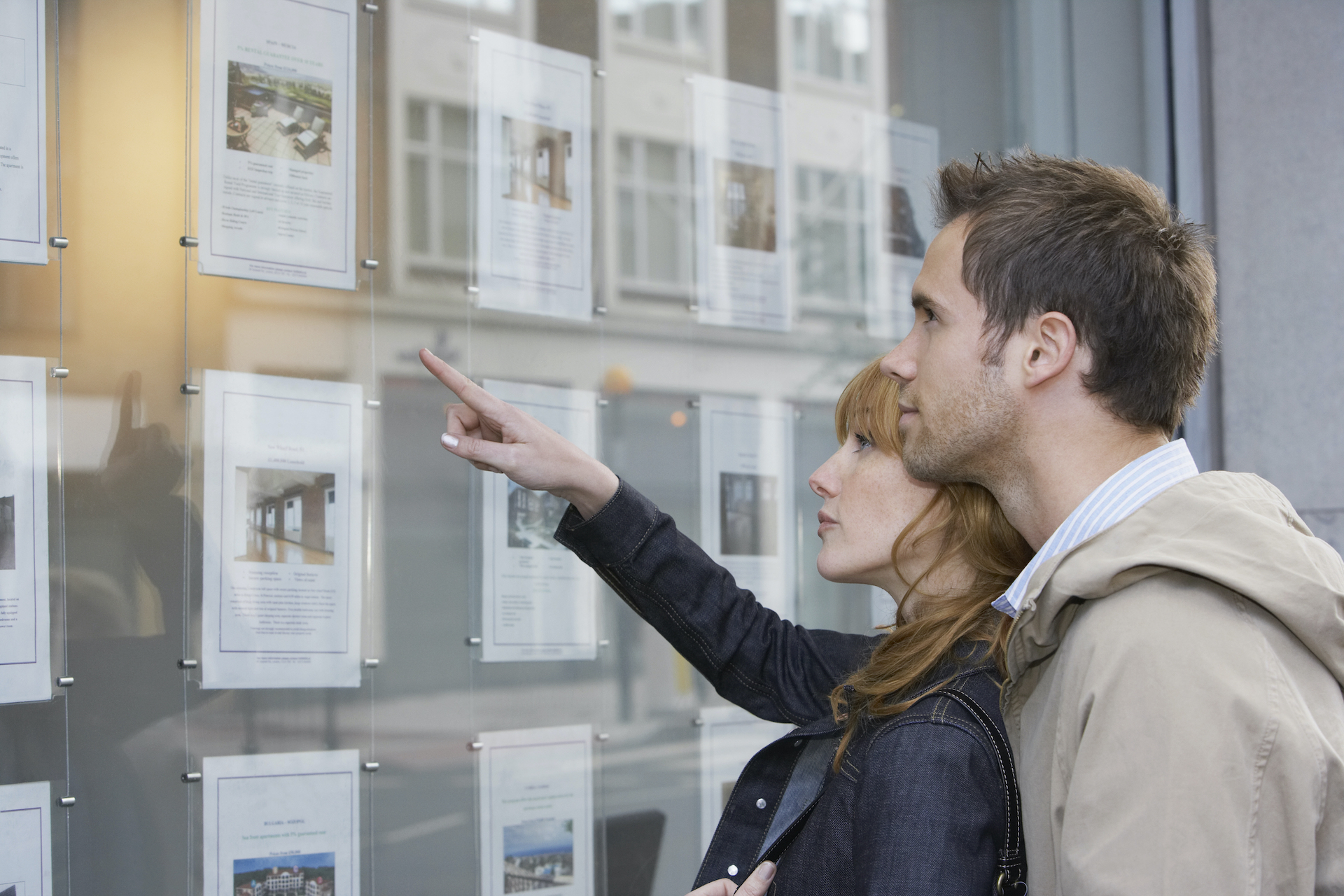 Side,View,Of,A,Young,Couple,Looking,At,Window,Display